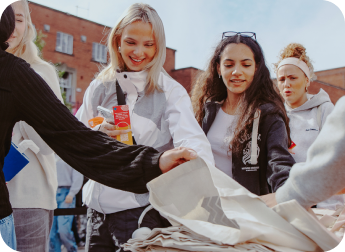 Students collecting tote bags at a campus activation